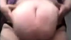 SSBBW in a purple dress plays with her giant belly